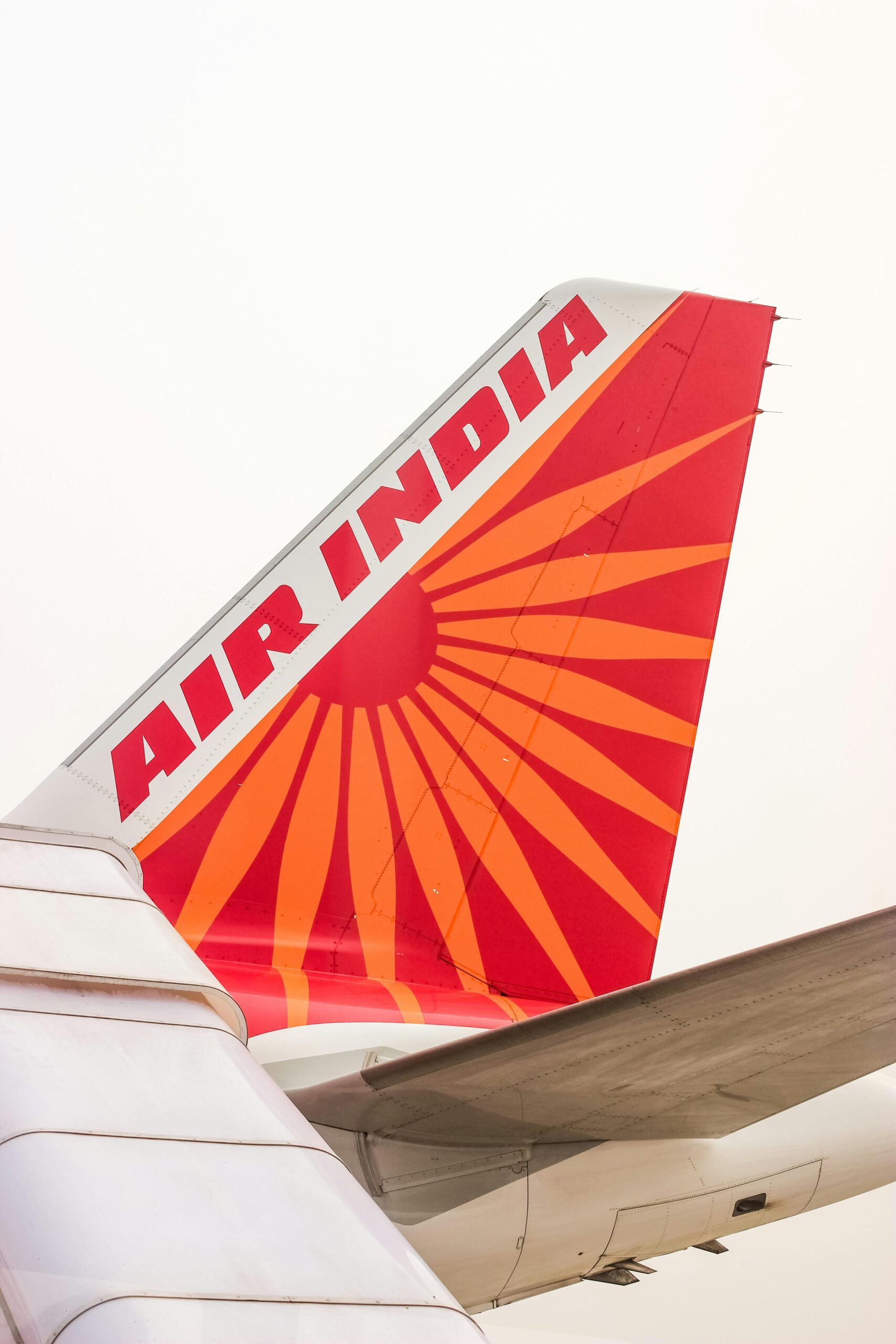 Air India Flight AI358 tail section showing the red and orange logo design at Delhi Airport